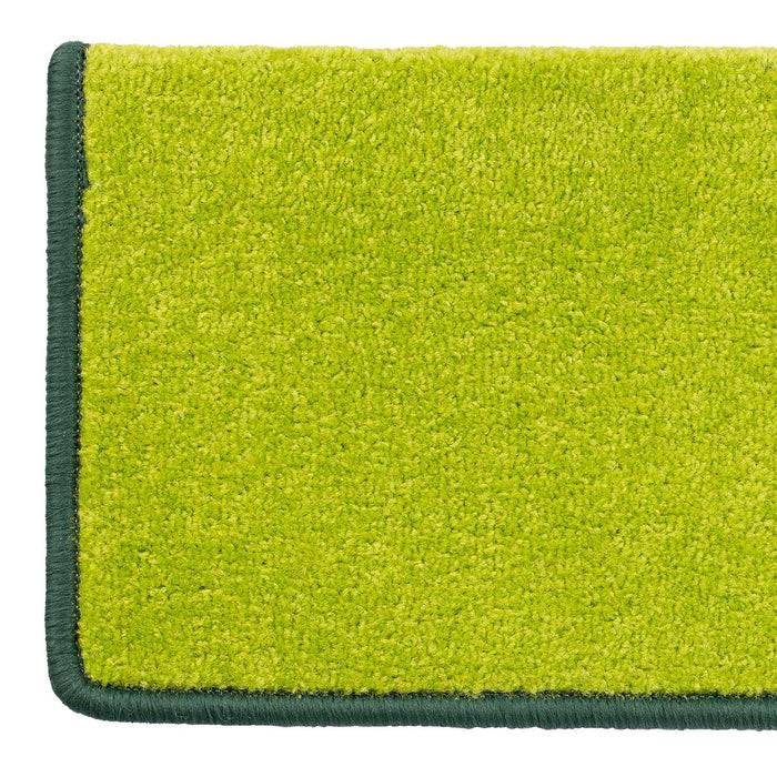 Ein rechteckiger hellgrüner Teppich mit dunkelgrünem Rand.