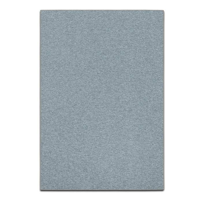 Eine Nahaufnahme einer Teppichkante, die eine dunkelbraune Oberfläche mit strukturierten Fasern zeigt. Die Unterseite ist sichtbar und hebt eine Gummirückseite hervor.