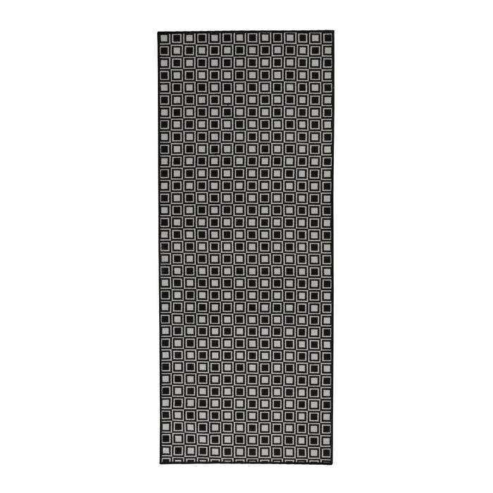 Eine schwarze Yogamatte mit einem Muster aus kleinen, gleichmäßig verteilten weißen Quadraten auf ihrer Oberfläche.