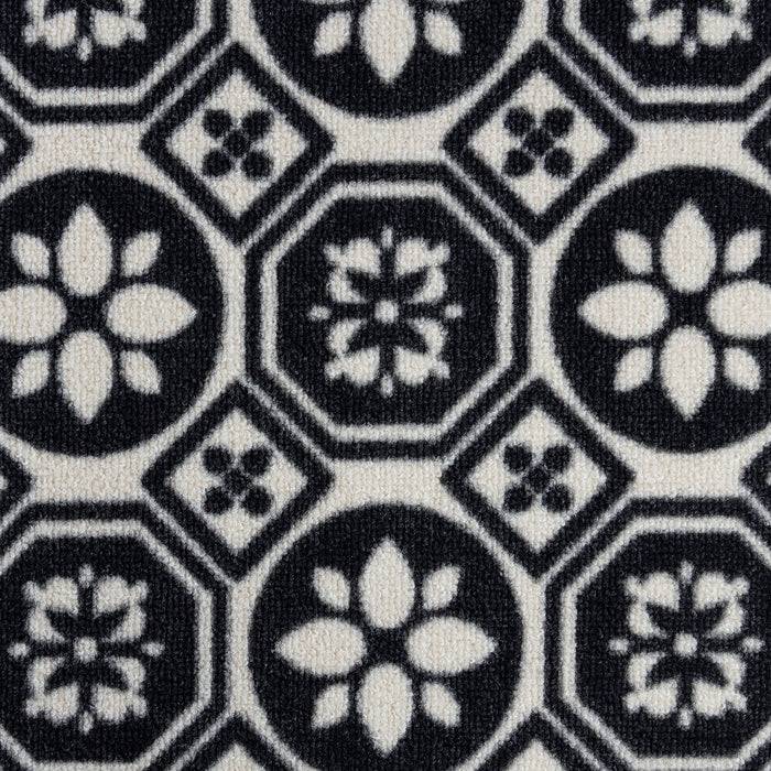 Geometrisches Muster mit schwarzen und weißen Blüten- und Diamantformen, angeordnet in einem sich wiederholenden Design auf Stoff.