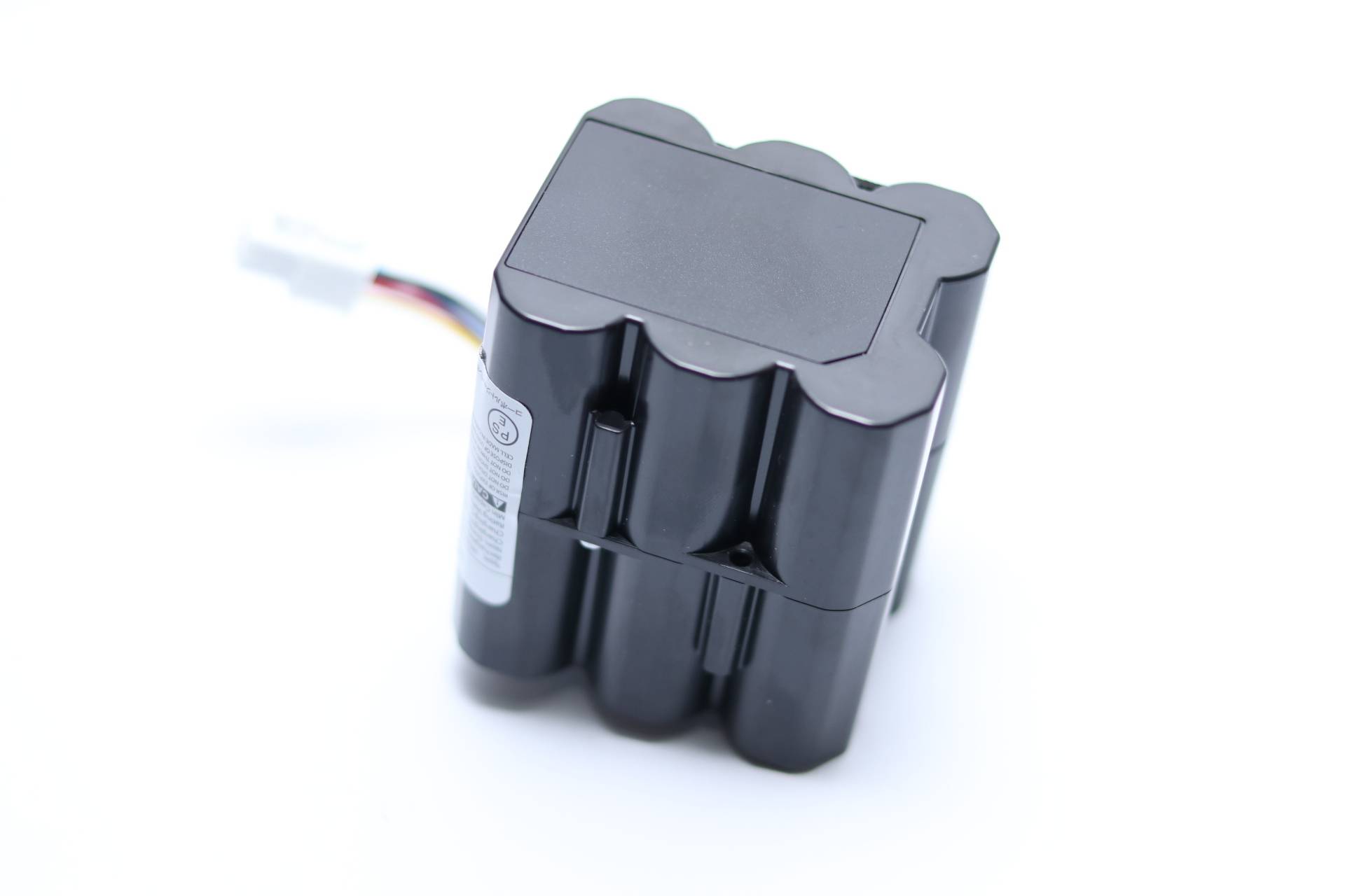 Ein schwarzes Lithium-Ionen-Akkupack mit mehreren verbundenen zylindrischen Zellen, mit weißem Aufkleber und einem kleinen angebrachten Draht mit Stecker.