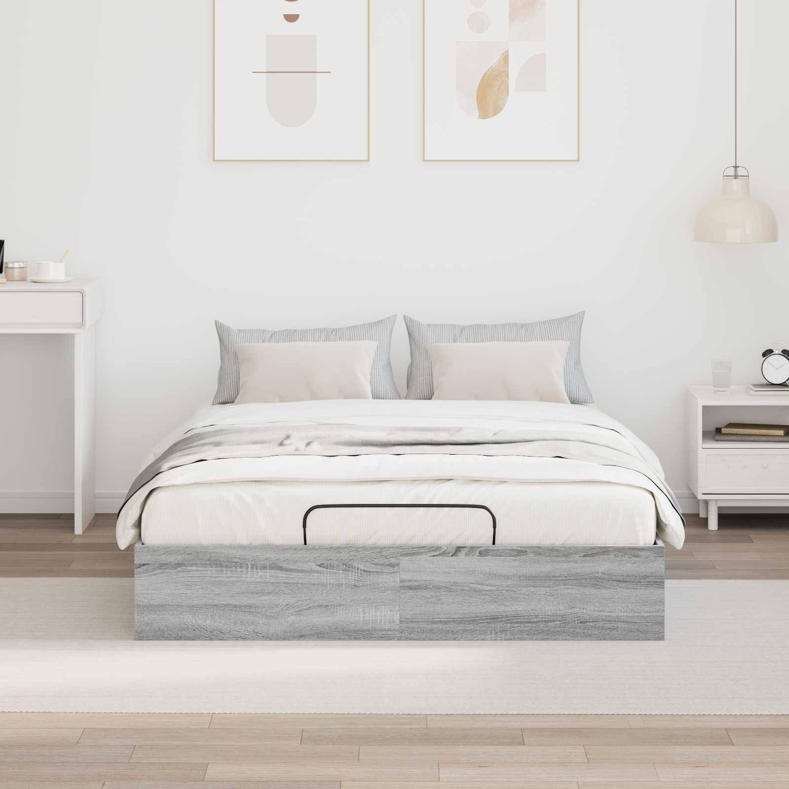 Ein modernes Schlafzimmer mit einem ordentlich gemachten Bett mit grauer Bettwäsche, flankiert von zwei minimalistischen Nachttischen. Zwei einfache Kunstwerke hängen über dem Bett.