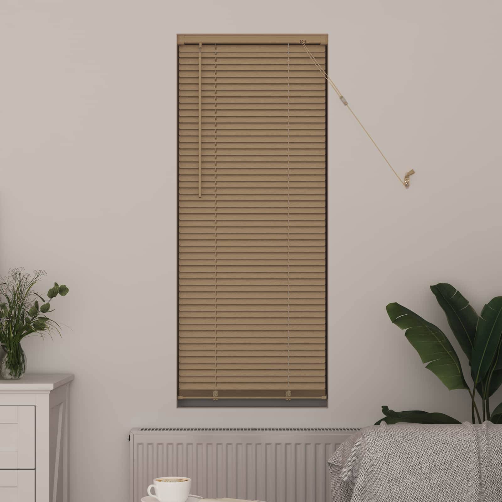 Eine beige Fensterrollo bedeckt ein hohes, schmales Fenster über einem weißen Heizkörper. Eine Topfpflanze und eine Tasse stehen auf leichten Möbeln in der Nähe.