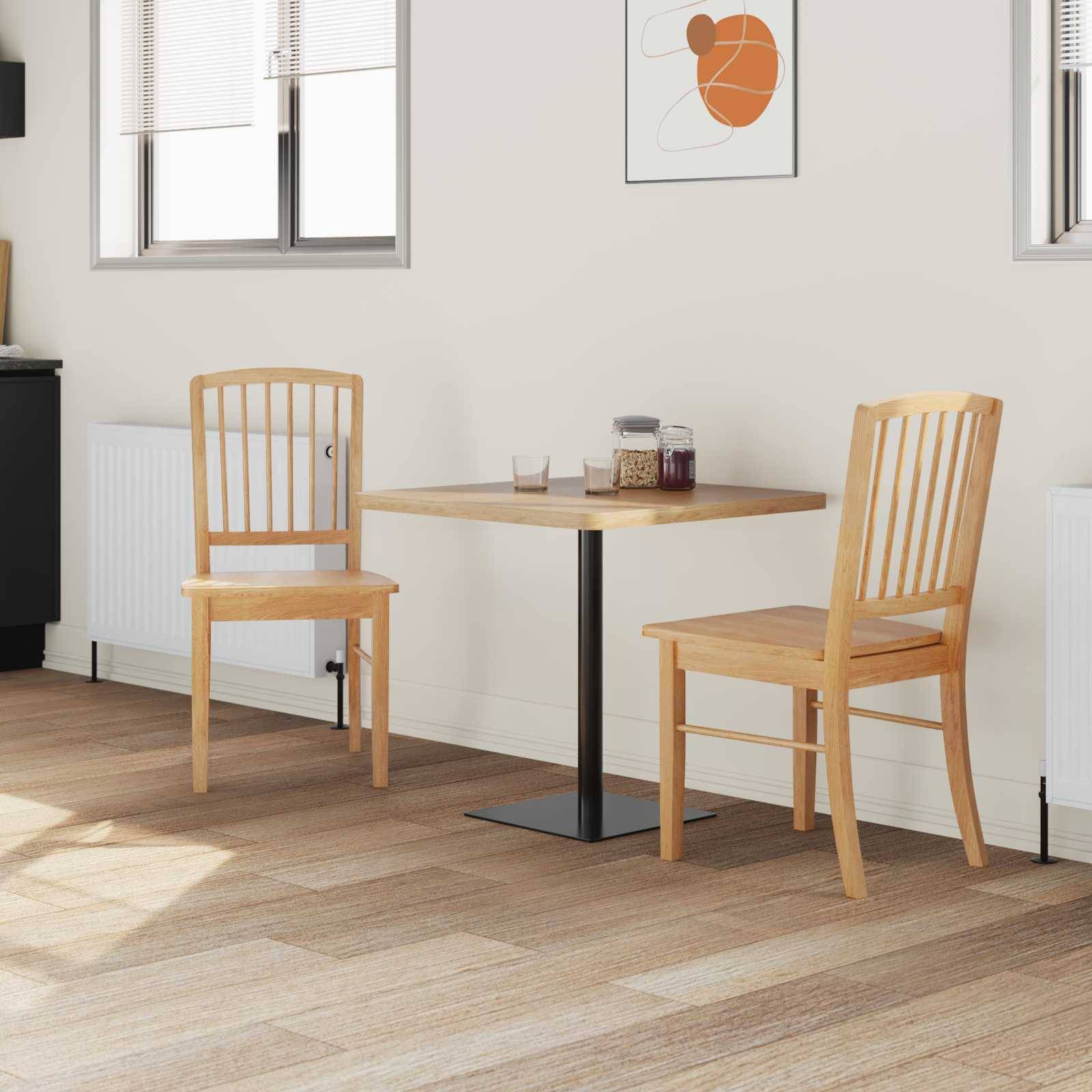 Eine kleine, moderne Küche mit einem Holztisch und zwei Stühlen, Sonnenlicht fällt durch Jalousien auf den hellen Holzboden.
