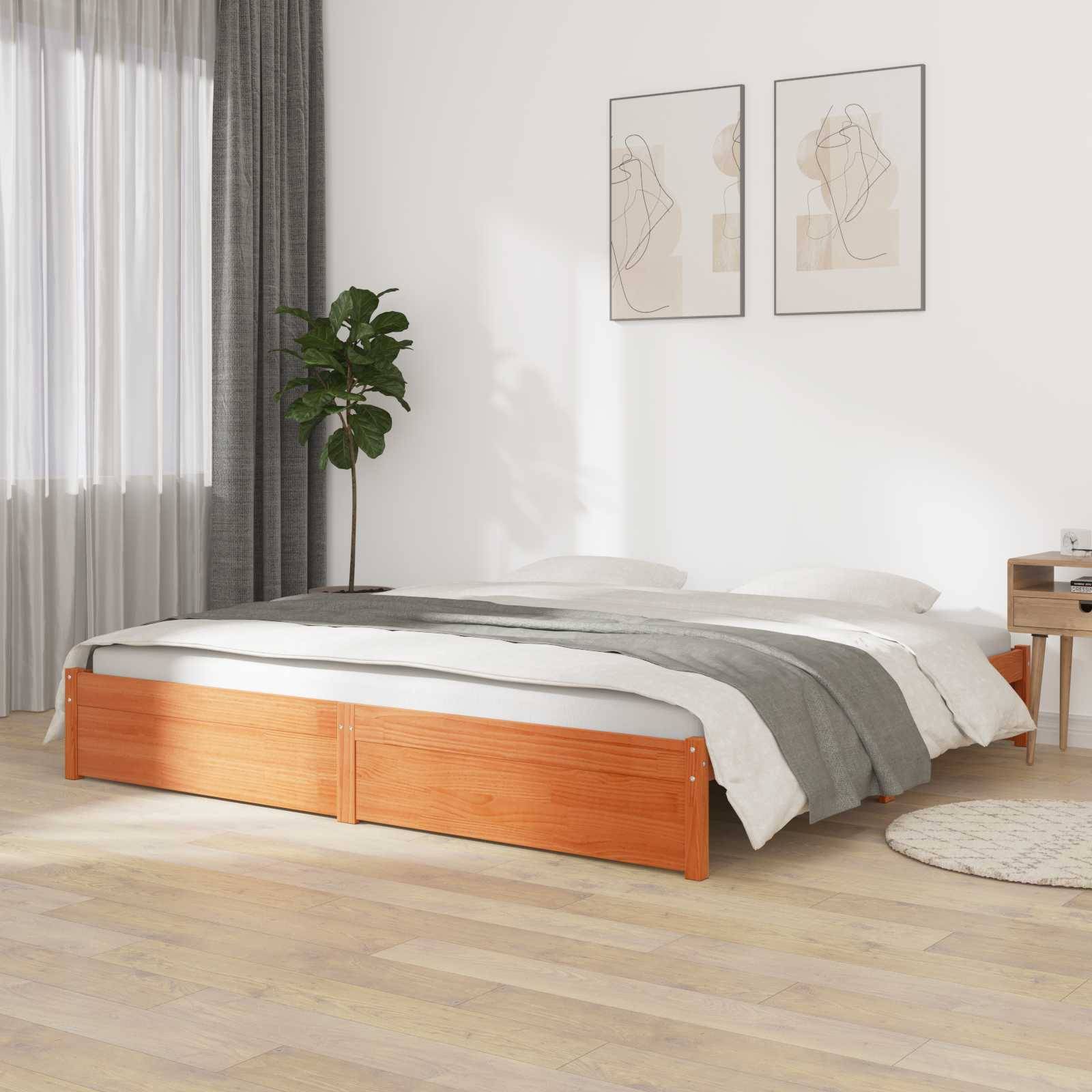 Ein minimalistisches Schlafzimmer mit einem Holzbett, grauer und weißer Bettwäsche, einer großen Pflanze am Fenster und gerahmter abstrakter Wandkunst.