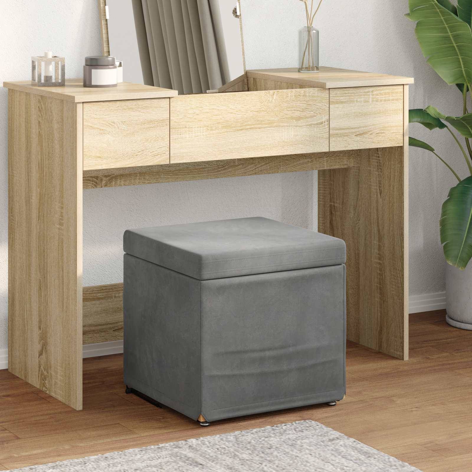 Ein Holzschreibtisch mit drei Schubladen, einem Spiegel und dekorativen Vasen. Ein grau gepolstertes Sitzkissen befindet sich darunter. Der Raum hat einen Holzboden.