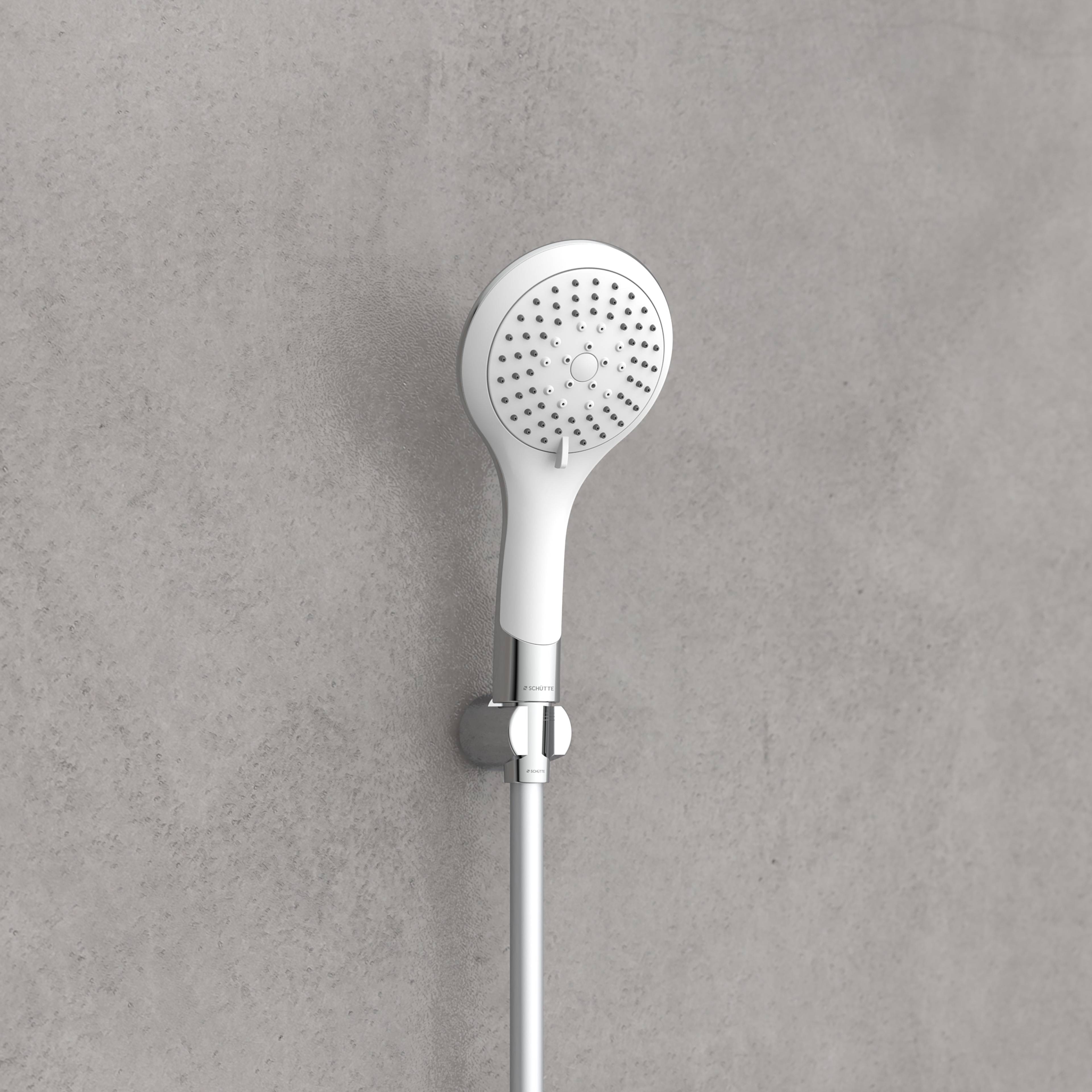 Ein weißer Duschkopf, der an einer grauen Wand montiert ist, mit sichtbaren Wasserspritzlöchern auf der Oberfläche des Kopfes. Der Duschkopf hat ein modernes Design.