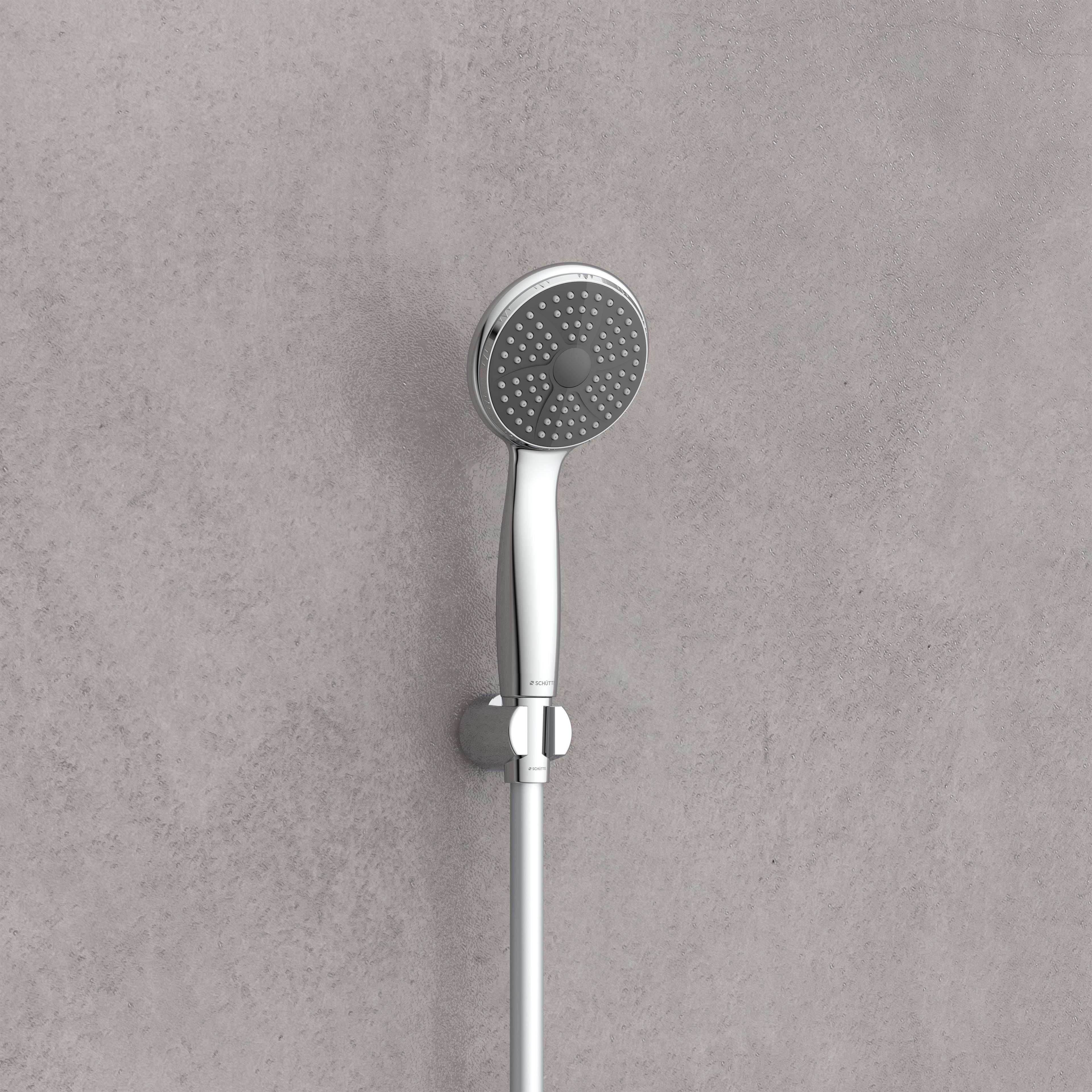 Ein moderner tragbarer Duschkopf mit rundem, durchlöchertem Gesicht und glänzendem Chromfinish, an einer Wand montiert.