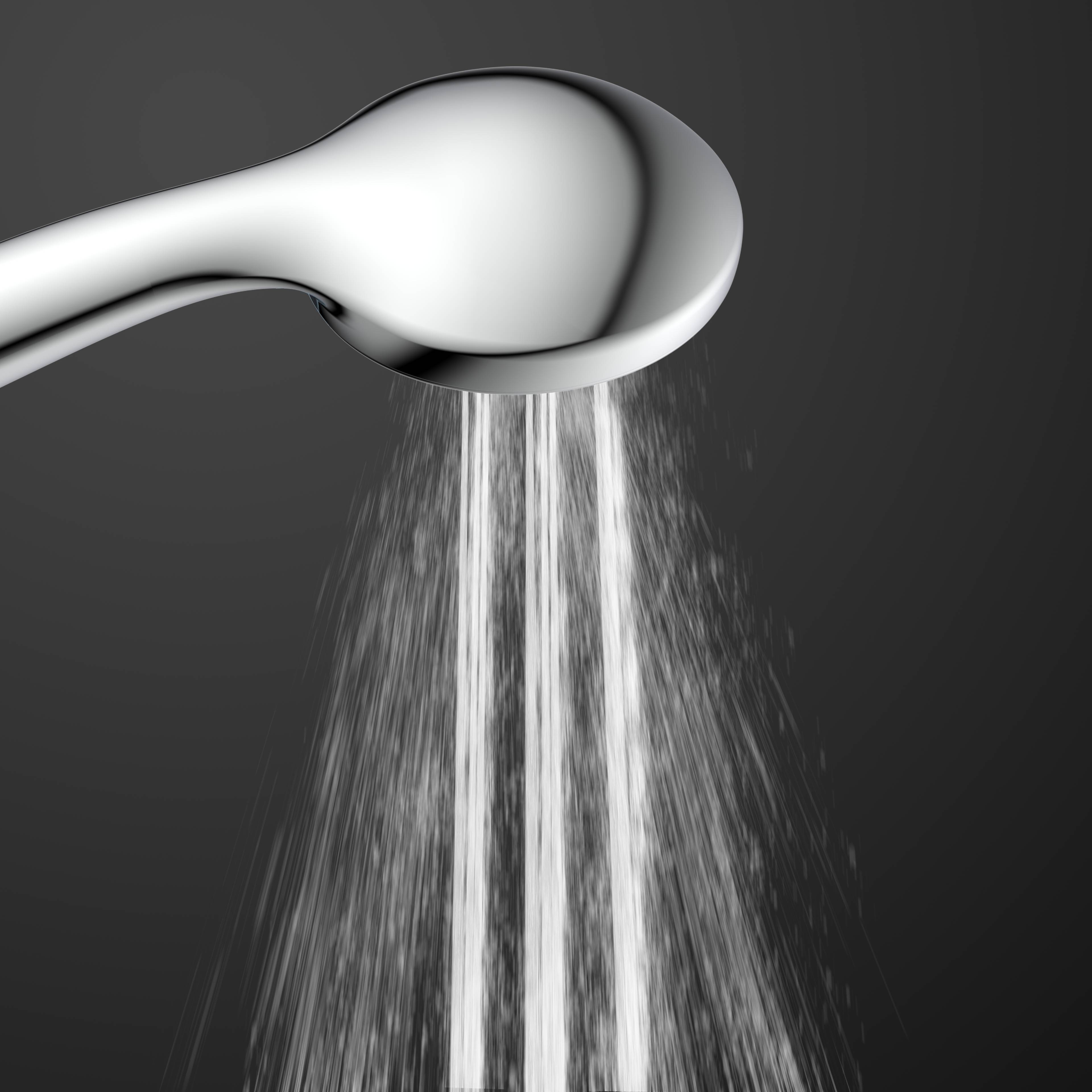 Ein silberner Duschkopf, der Wasser in eine Abwärtsrichtung gegen einen dunkelgrauen Hintergrund sprüht.