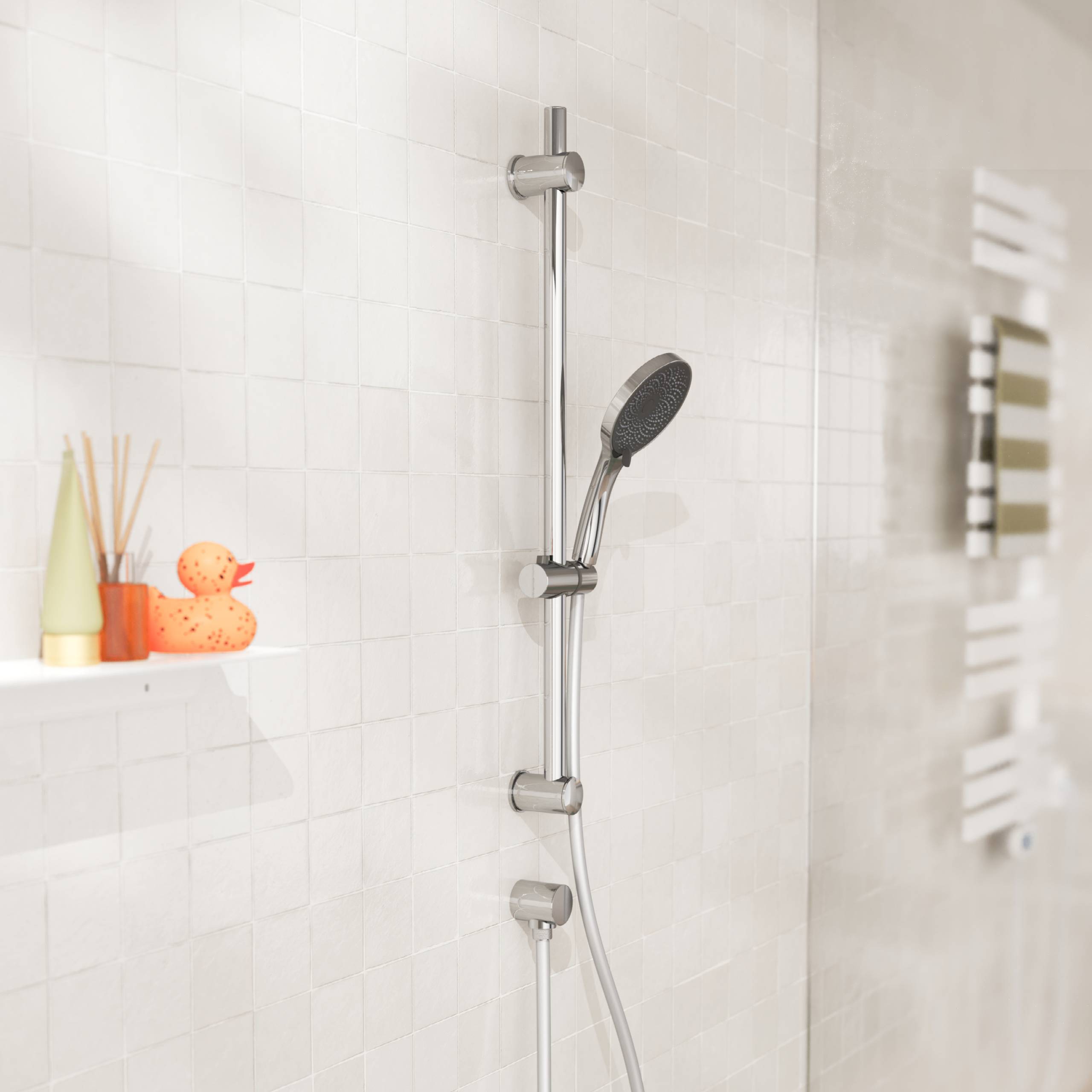Moderne geflieste Dusche mit Chromduschstange und Handbrauseduschkopf, plus ein kleines Regal mit Badeutensilien und einer Gummiente.