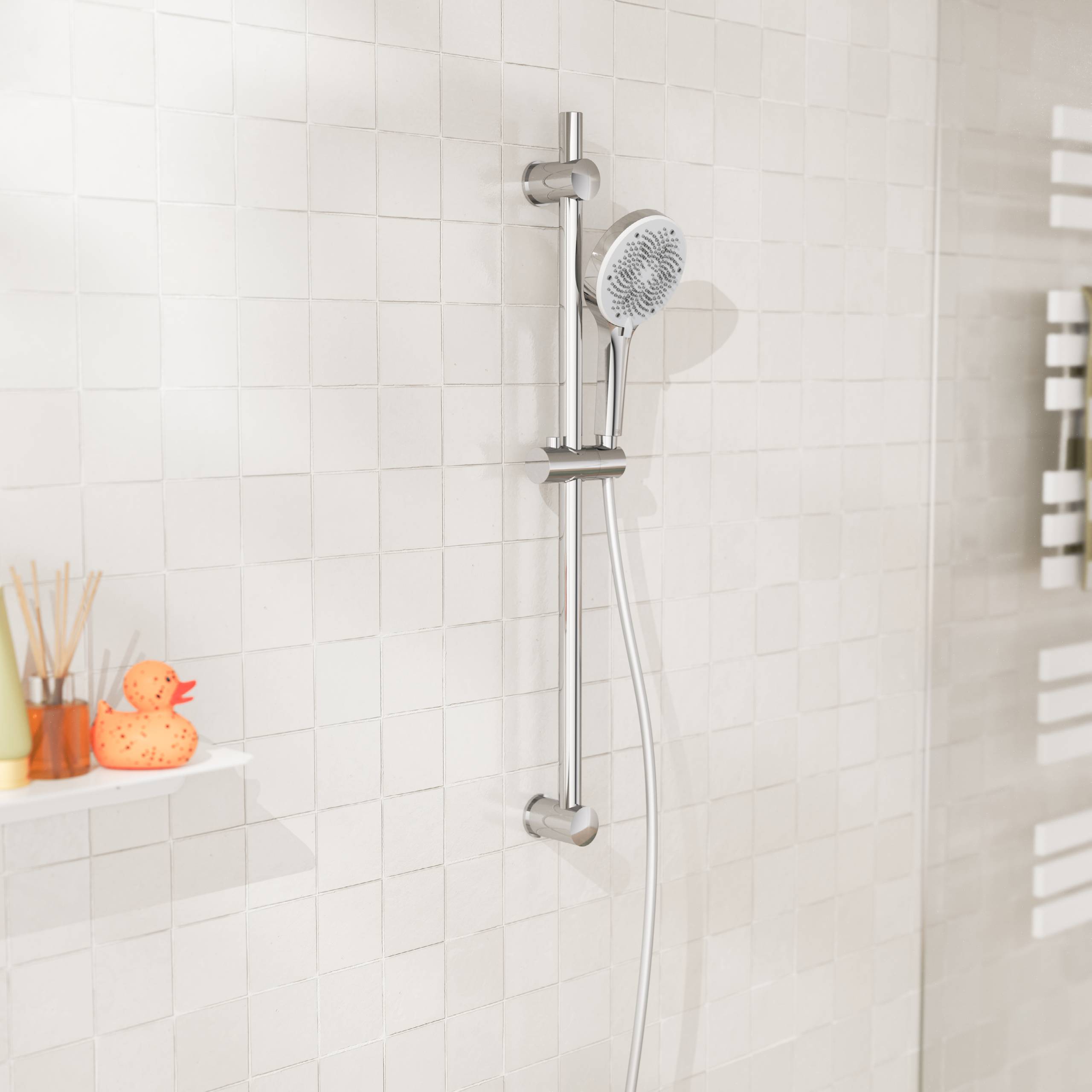 Eine weiße geflieste Duschwand mit einem verstellbaren Duschkopf aus Metall. Ein kleines Regal hält eine Ente aus Gummi und Zahnbürsten.