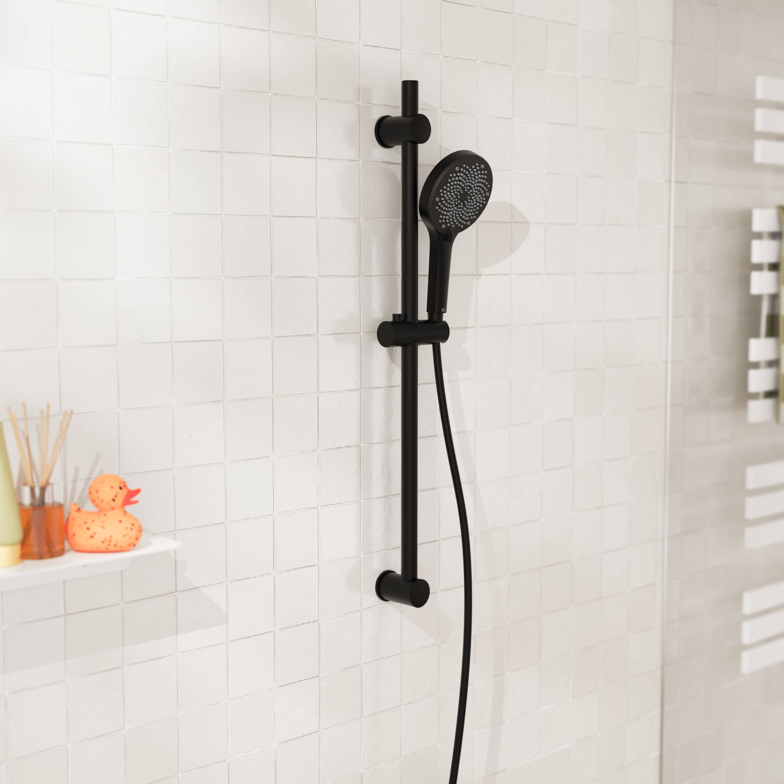 Schwarze tragbare Dusche auf einer vertikalen Schiene, die an einer weiß gekachelten Badezimmerwand montiert ist, mit einem kleinen Regal mit Badezimmerutensilien auf der linken Seite.