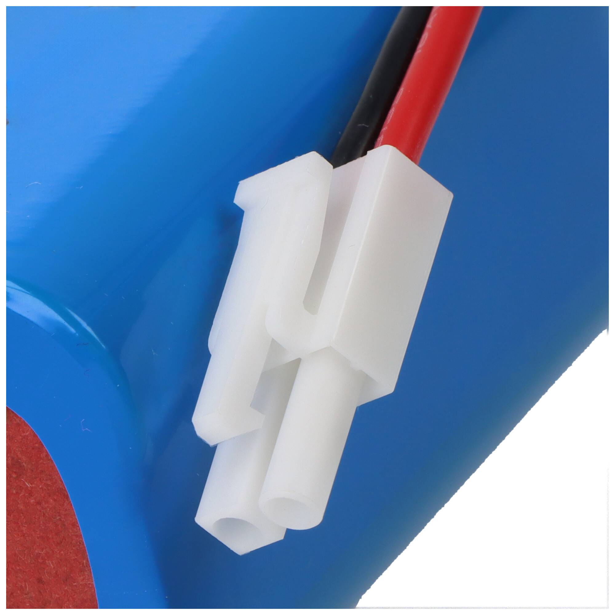 Ein weißer Elektrostecker mit roten und schwarzen Drähten auf blauem Hintergrund befestigt, wahrscheinlich für eine Batterie- oder Elektronikgerätverbindung.
