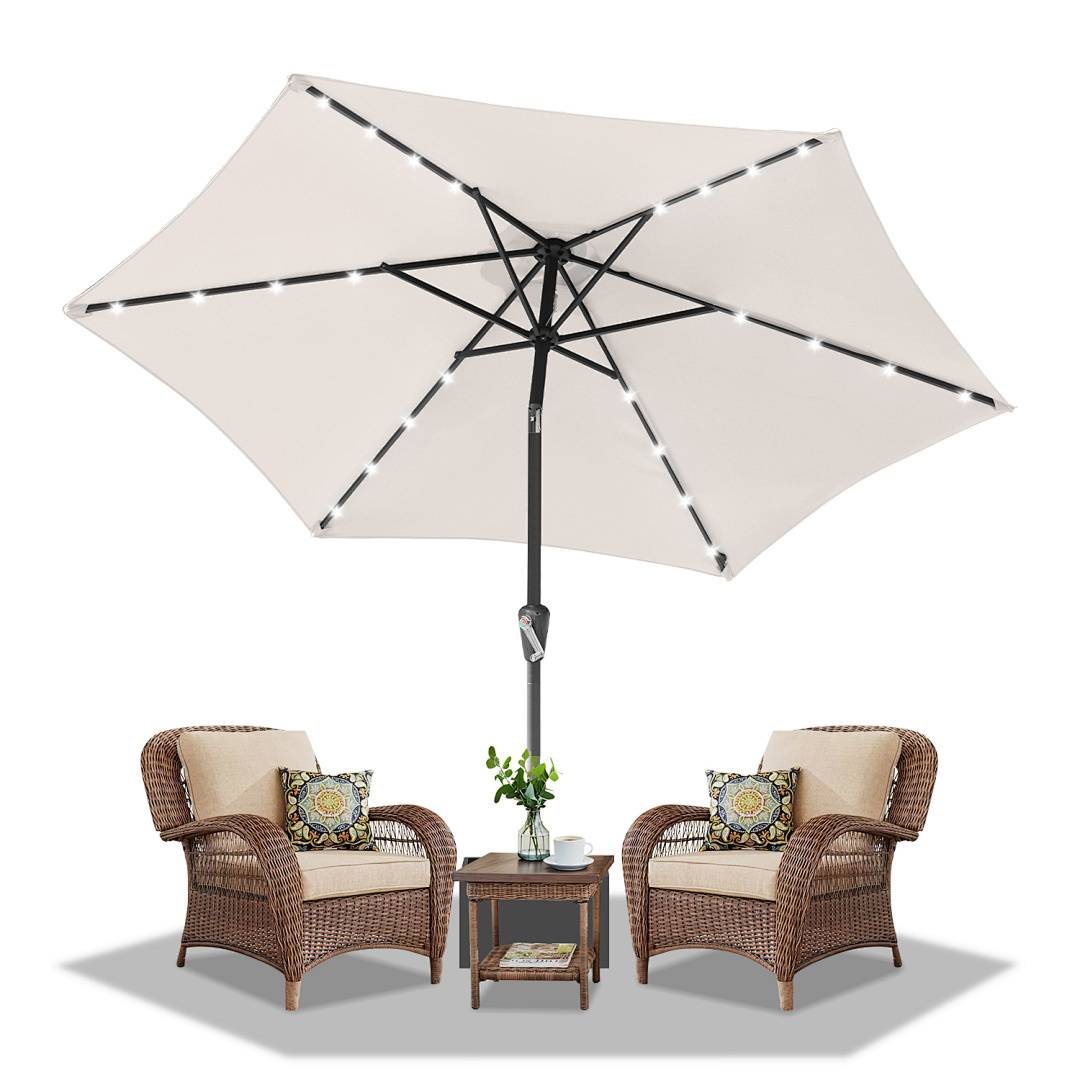 Outdoor-Sitzmöbel bestehend aus zwei Korbstühlen mit Kissen, einem kleinen zentralen Tisch mit einer Pflanze und einem großen Schirm darüber.