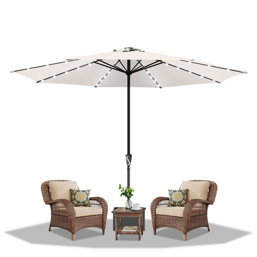 Zwei Korbstühle mit Kissen und ein kleiner Tisch stehen unter einem großen offenen weißen Schirm. Eine Topfpflanze auf dem Tisch verleiht Grün.