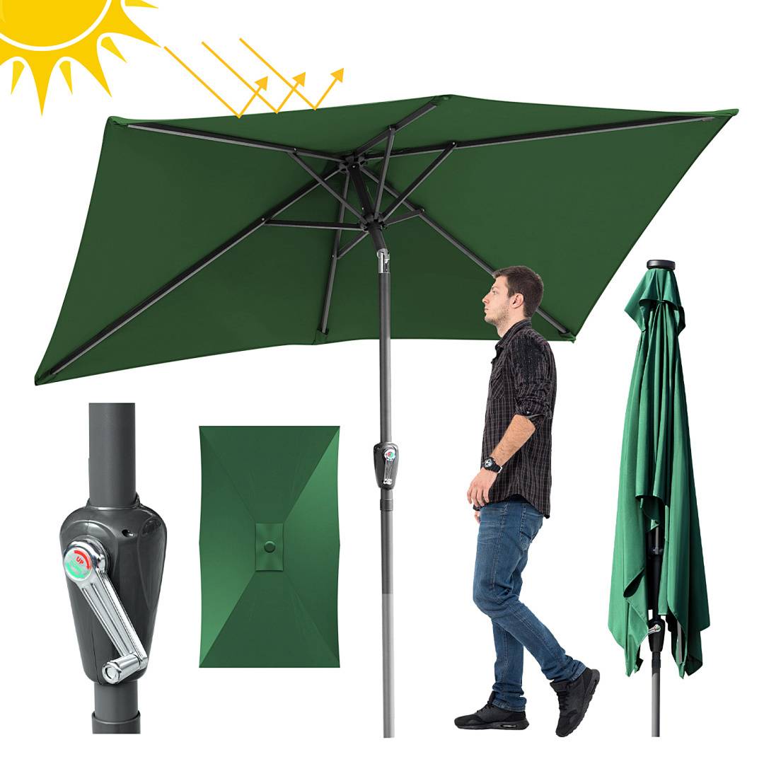 Ein Mann steht neben einem großen grünen Terrassenschirm mit einer Kurbel. Gelbe Pfeile zeigen die Fähigkeit des Schirms, Sonnenlicht zu blockieren.