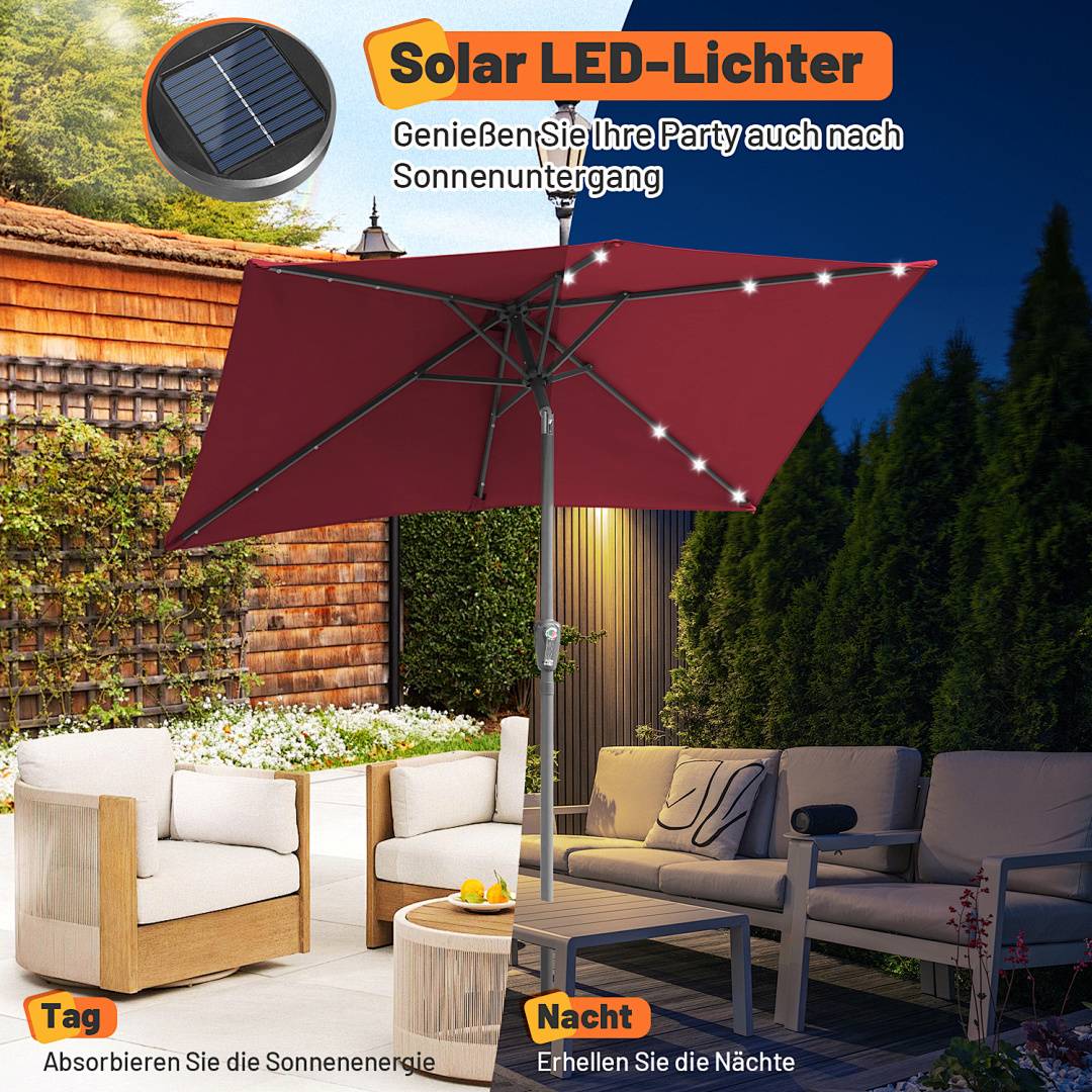 Rote Terrassenmarkise mit LED-Leuchten in einer Gartenumgebung, ausgestattet mit einem Solarpanel auf der oberseite. Der Text lautet: „Genießen Sie Ihre Party auch nach Sonnenuntergang.