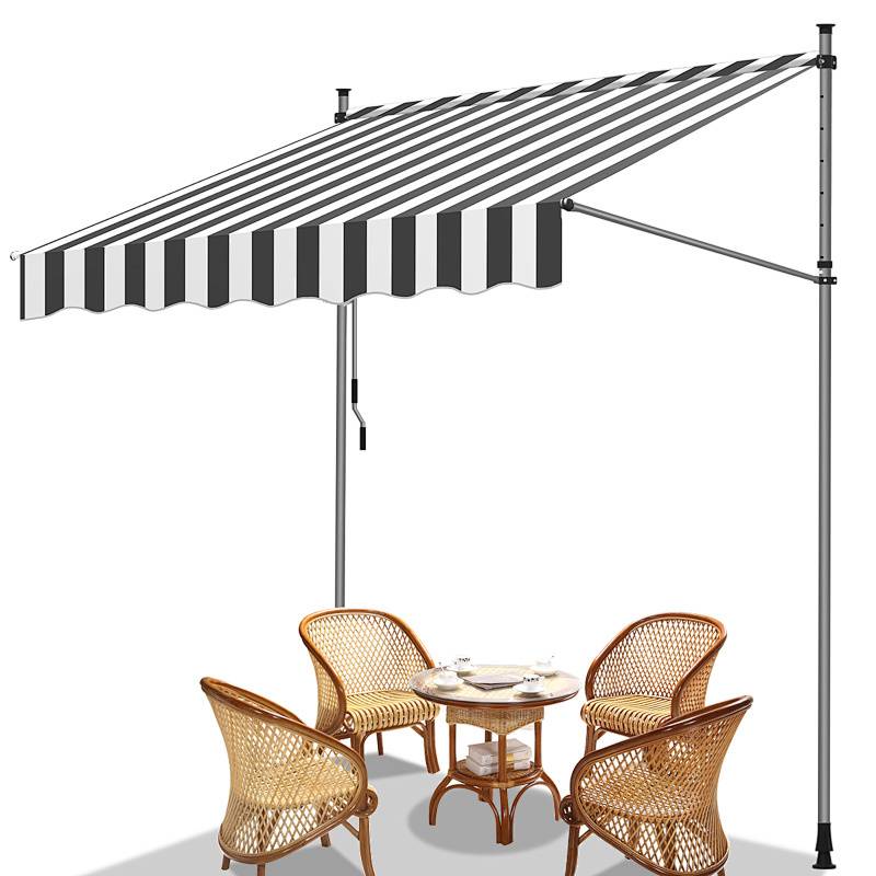 Vier Korbstühle und ein kleiner Tisch unter einer großen schwarz-weißen gestreiften ausziehbaren Markise.