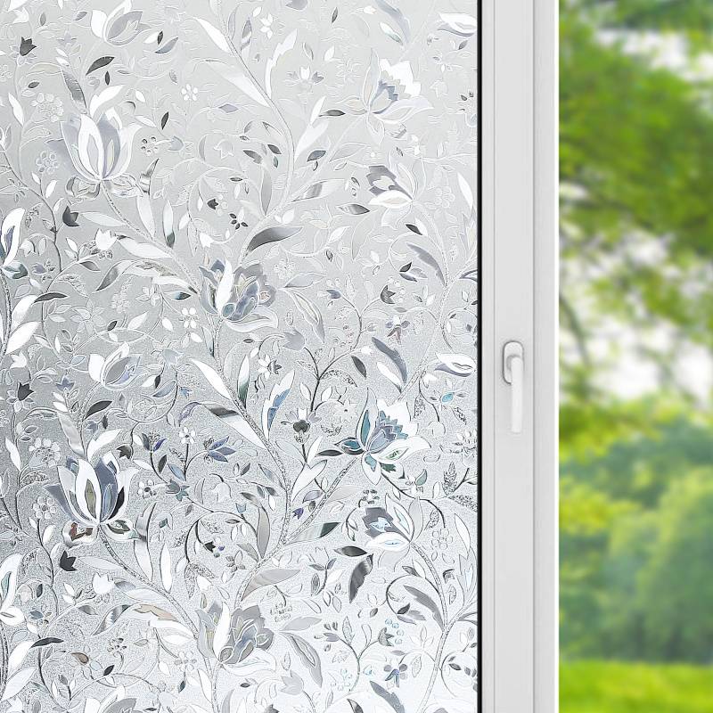 Ein dekoratives Fenster mit einem aufwendigen floralen Mattglasdesign, teilweise geöffnet, mit unscharfem grünem Außenhintergrund sichtbar.