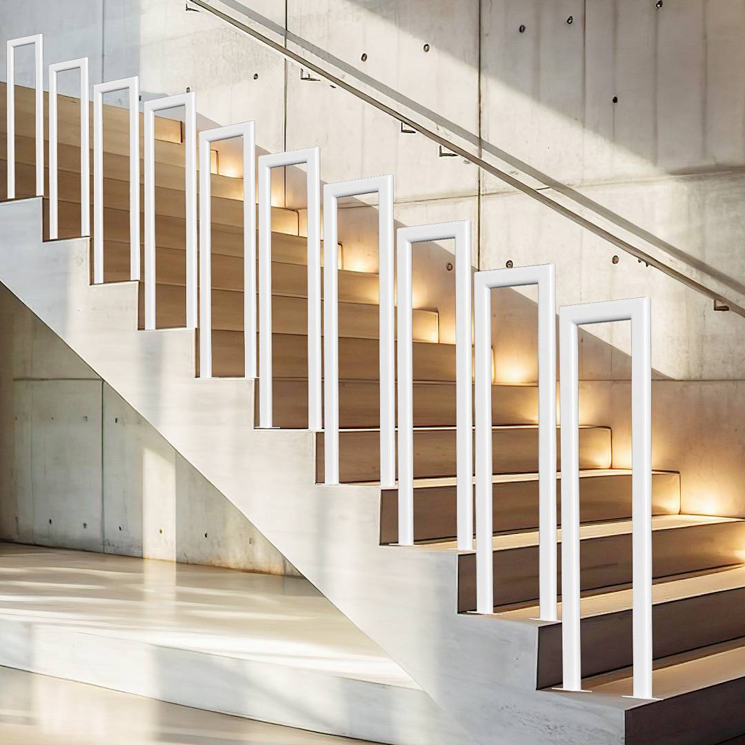 Eine moderne Treppe mit Holzstufen und weißem Geländer in einem hellen, betonummauerten Innenraum, mit Sonnenlicht, das durch Fenster strömt.
