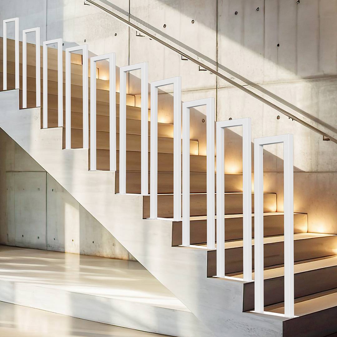 Eine moderne Treppe mit Holzstufen und weißen senkrechten Geländern, vor einer beigen Betonwand, wird von natürlichem Licht beleuchtet.