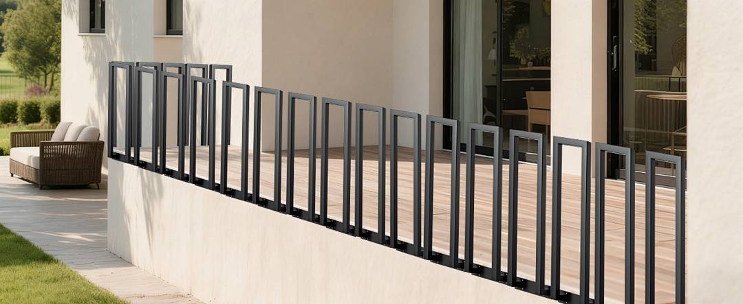 Ein moderner Balkon mit vertikalem schwarzem Metallgeländer, hellem Holzboden und einer Glastür, die zu einem Innenraum führt.