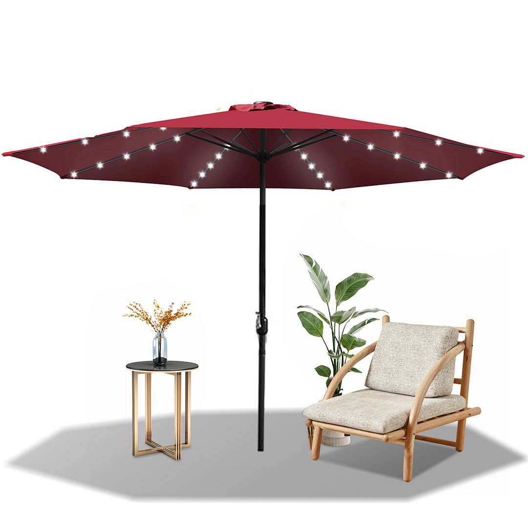 Ein roter Terrassenschirm mit LED-Lichtern ist über einem Holzstuhl und einem kleinen Tisch mit einer Blumenvase aufgespannt, neben einer grünen Pflanze.