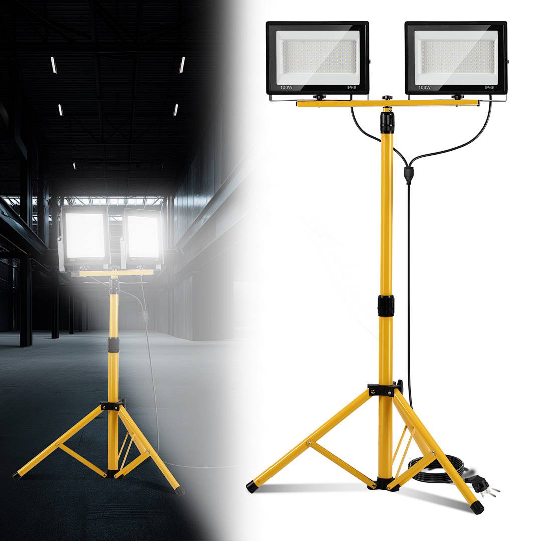 Ein LED-Arbeitsleuchte mit doppeltem Kopf und gelbem Ständer wird in einem schwach beleuchteten Lagerhaus gezeigt.