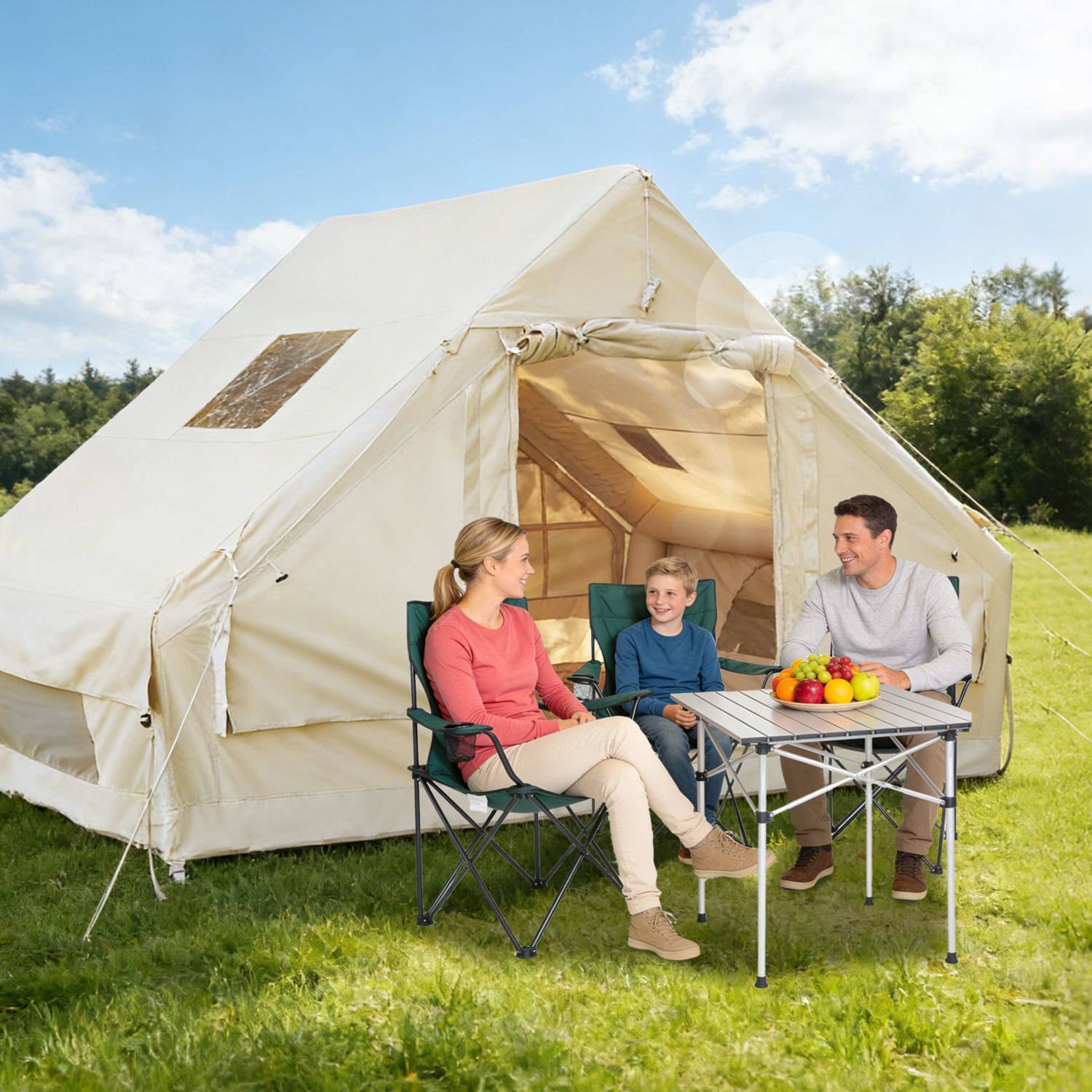 Eine dreiköpfige Familie sitzt an einem sonnigen Tag außerhalb eines beigen Zeltes und unterhält sich an einem tragbaren Tisch mit einer Obstschale.