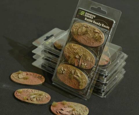 Ein Satz von Miniatur-Basen mit Risserde-Textur in Verpackung, entworfen für Tischspiele. Mehrere Basen sind außerhalb ausgestellt.