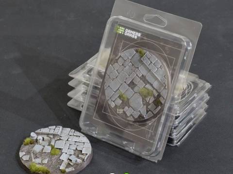Ein Stapel verpackter Miniatur-Basisgelände mit Steinpflaster-Design und Moosdetails, verwendet für Verbesserungen der Tischplattenspiel-Szenerien.