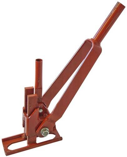 Ein rotes Farmheber mit langem Griff und mechanischer Basis, das zum Heben schwerer Landmaschinen und Fahrzeuge in landwirtschaftlichen Umgebungen verwendet wird.