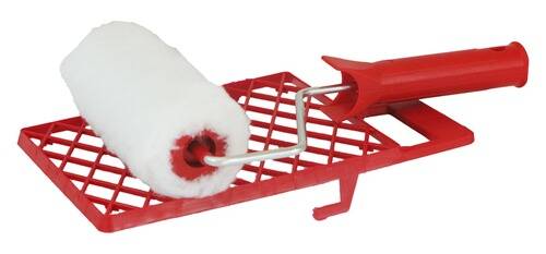 Eine Farbrolle mit einem weißen, flauschigen Bezug ruht auf einer roten Gitterschale, die zum gleichmäßigen Verteilen von Farbe während des Anstrichs verwendet wird.