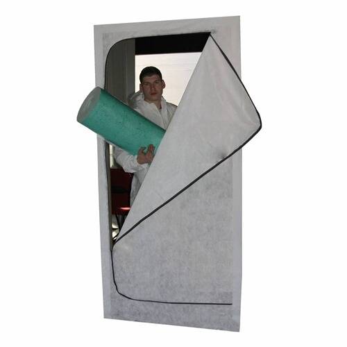 Eine Person in Schutzkleidung geht durch eine Türöffnung mit einer teilweise geöffneten Reißverschlussabdeckung hindurch und trägt ein grünes zylindrisches Objekt.