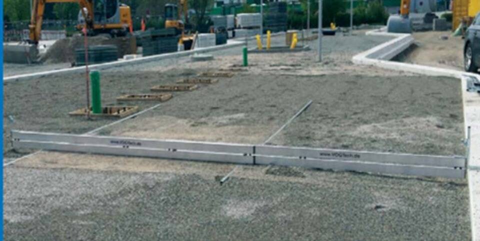 „Baustelle mit Kiesuntergrund und Maschinen im Hintergrund, Vorbereitung für Straßenbelag oder Infrastrukturentwicklung.