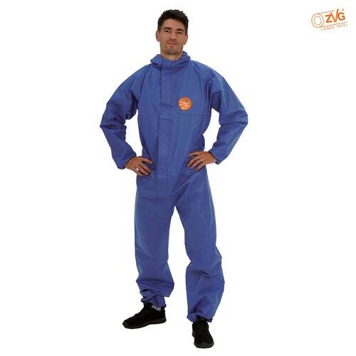 Eine Person, die einen blauen Schutzanzug trägt, steht mit den Händen in die Hüften gestützt. Der Anzug hat ein Aufnäher mit einem kreisförmigen Logo.