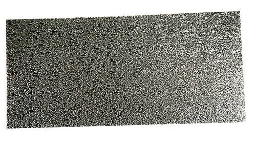 „Ein strukturiertes Metallblatt mit einer rauen, körnigen Oberfläche, die Licht ungleichmäßig reflektiert und einen schimmernden Effekt erzeugt.