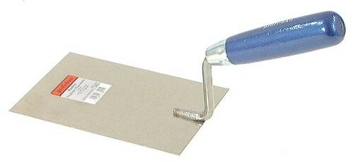 Eine gezahnte Kelle mit blauem Griff, die auf einer ebenen Fläche ruht und zum Auftragen von Klebstoff verwendet wird.