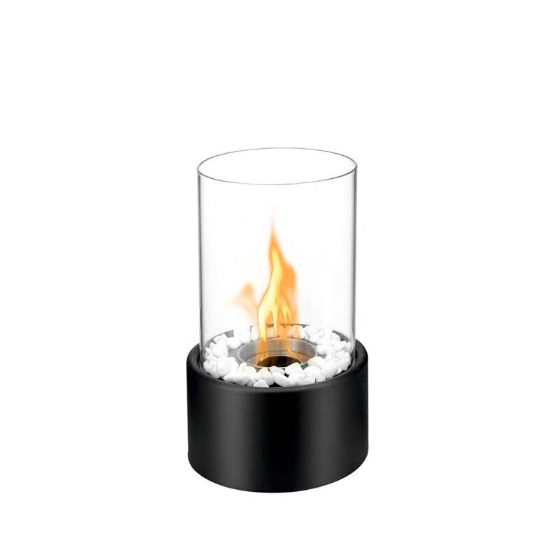 Ein dekoratives Tischkamin aus Glas und schwarzem Metall mit sichtbarer Flamme, umgeben von weißen Steinen, verwendet für Atmosphäre.