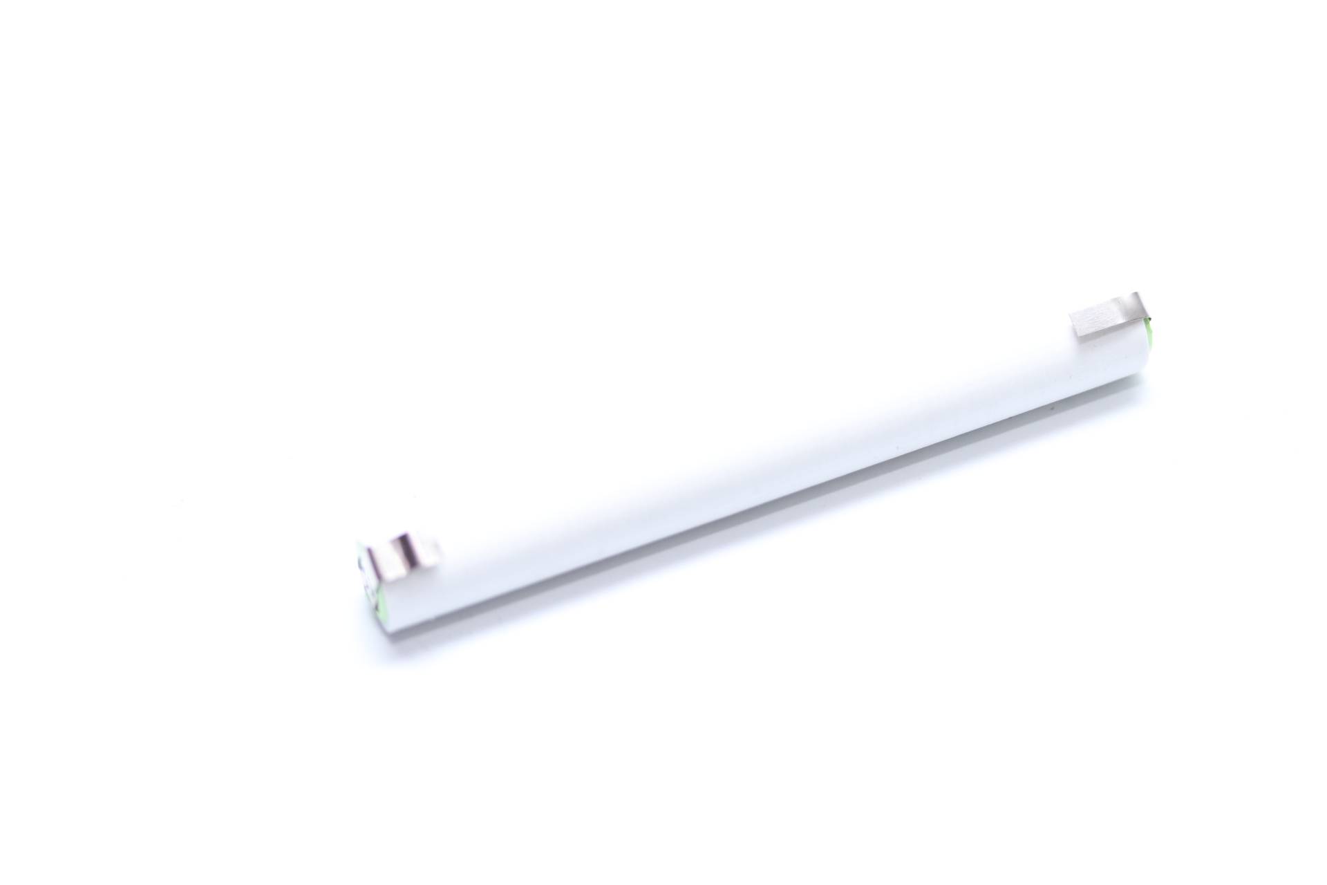 Ein weißes, längliches Objekt mit einer kleinen, metallischen Komponente an einem Ende, auf weißem Hintergrund betrachtet.