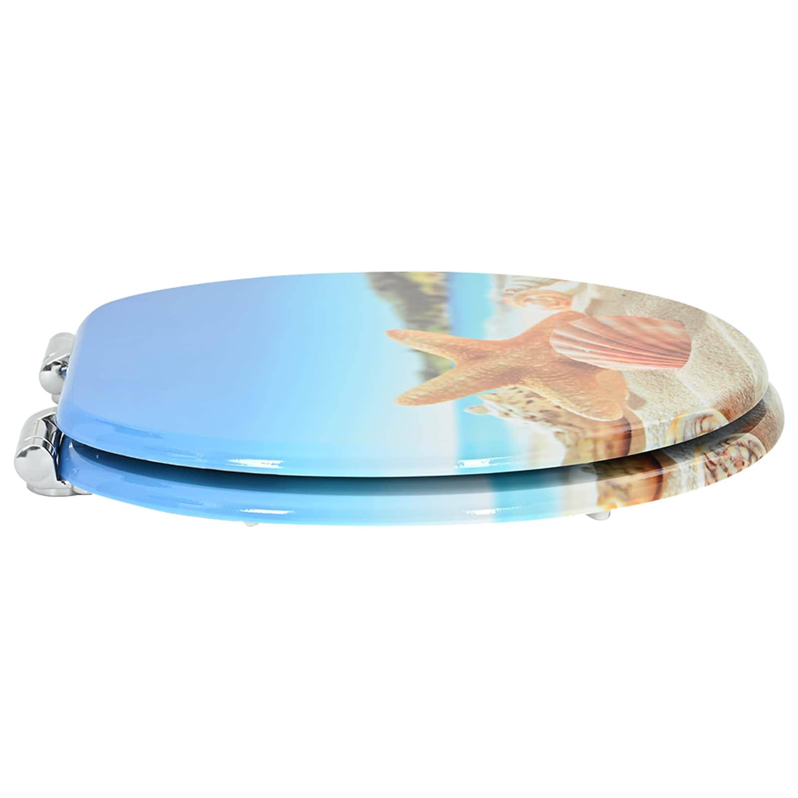 Ein geschlossener Toilettensitz mit einem Strandthema-Design mit einem Seestern und Muscheln im Sand, vor einem blauen Himmel.