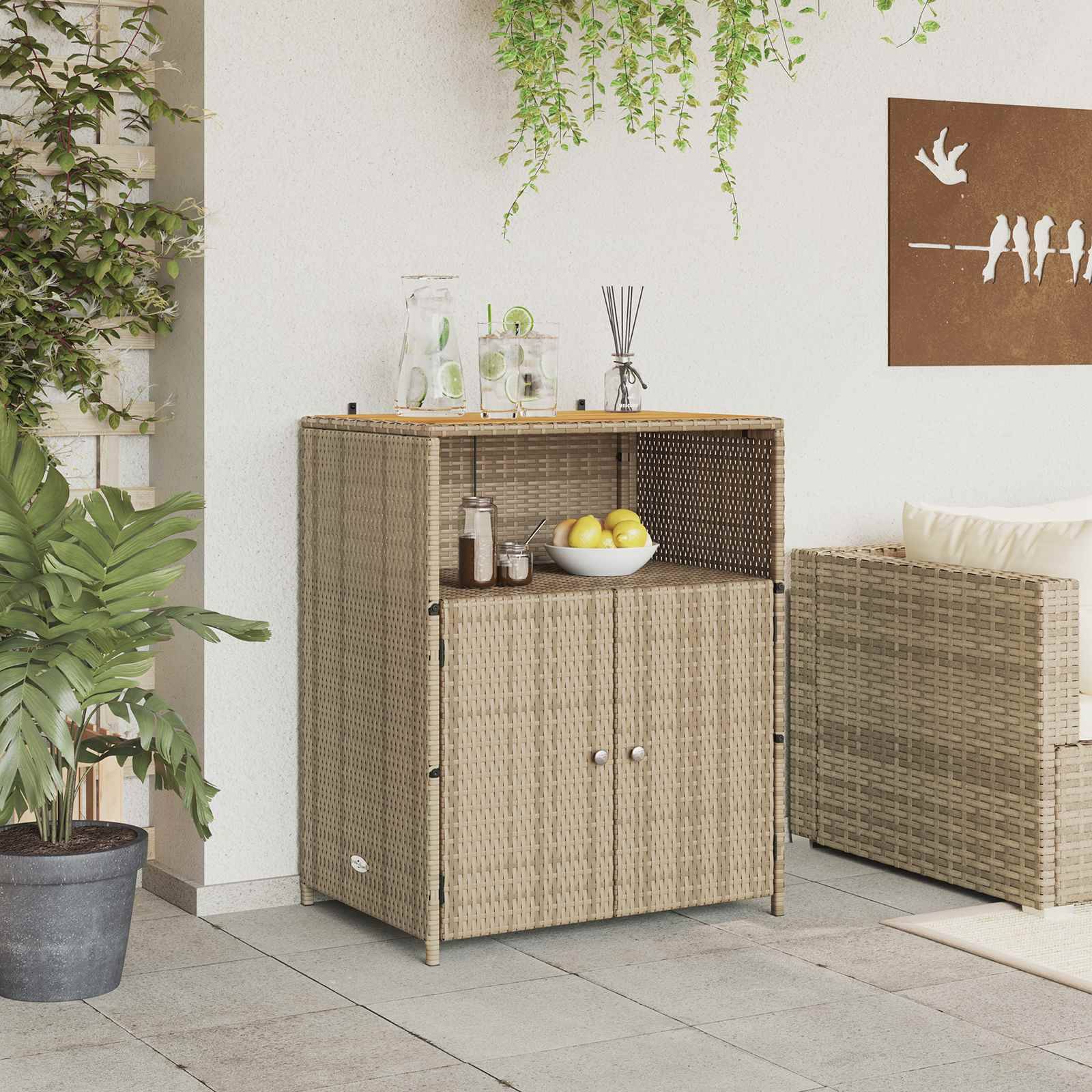 Ein Outdoor-Schrank im Rattanstil mit Getränken und Gläsern oben, umgeben von grünen Pflanzen. Ein Wandkunstwerk zeigt Silhouetten von Menschen.