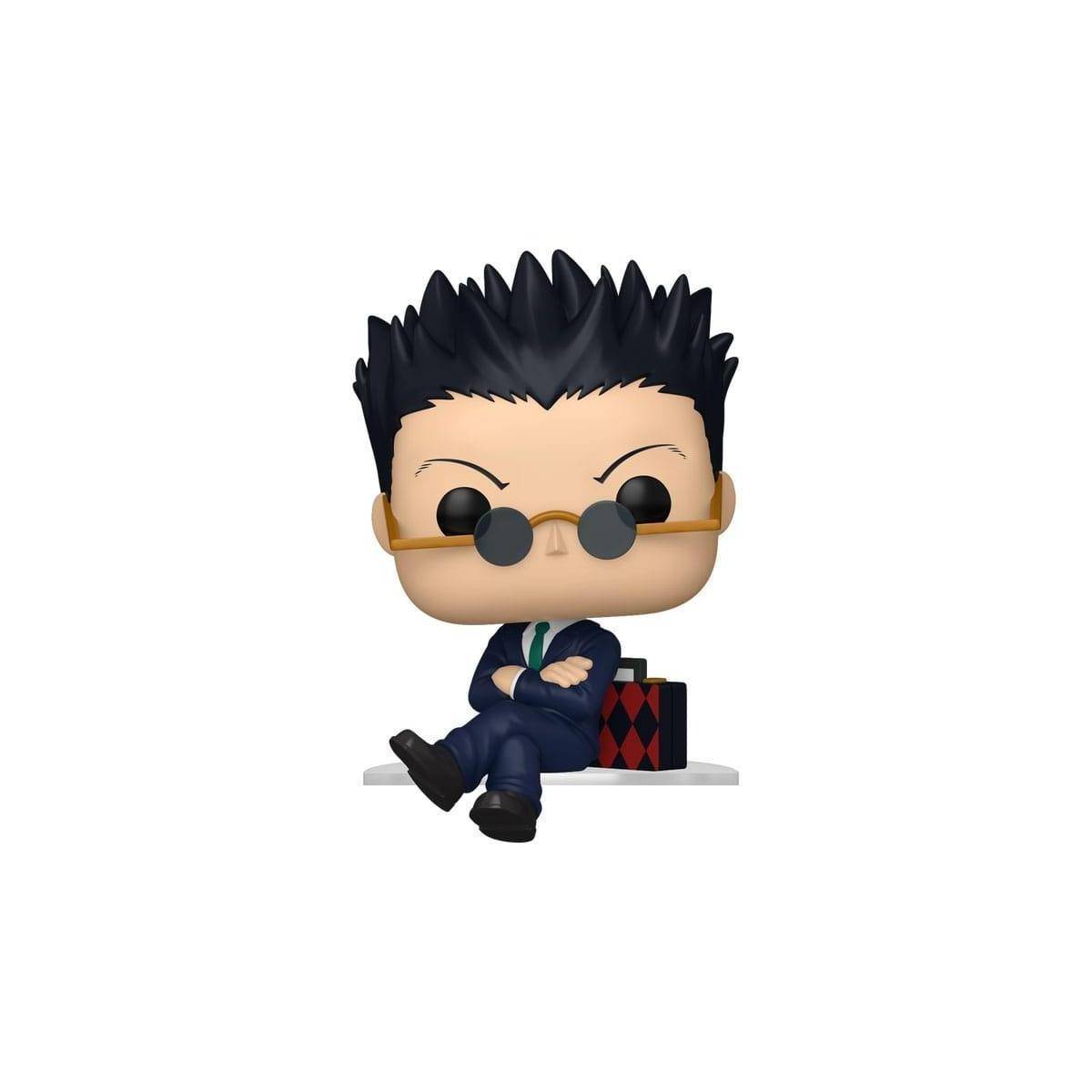 Eine stilisierte Vinylfigur einer Person mit stacheligen schwarzen Haaren, die eine Sonnenbrille und einen Anzug trägt und mit gekreuzten Beinen auf einer Oberfläche sitzt.