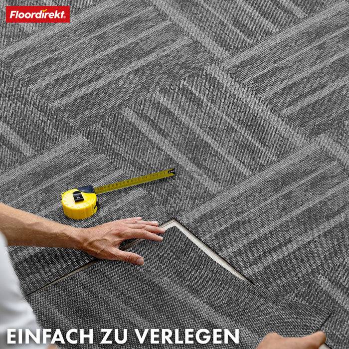 Floordirekt Logo. Jemand verlegt dunkelgraue Teppichfliesen mit einem Maßstab in der Nähe. Text: Einfach zu verlegen (Einfach zu installieren).