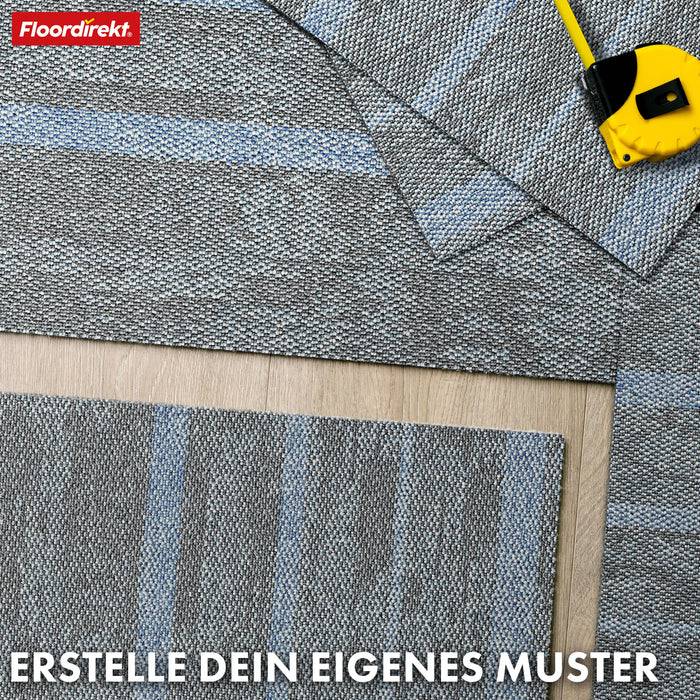 Überlappende graue Teppichfliesen mit einem gelben Maßstab auf einem Holzboden. Der Text lautet „Erstelle dein eigenes Muster.
