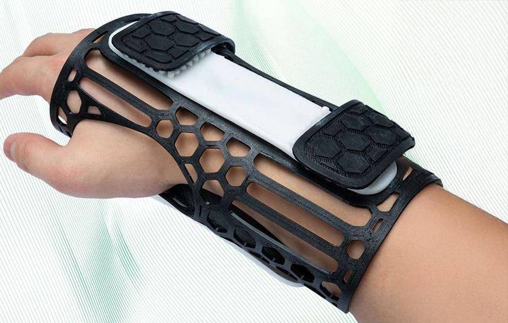 Zwei Spulen mit 3D-Druckerfaden, eine grün und eine weiß, mit zwei Handyhüllen in Grün und Blau, was darauf hindeutet, dass sie 3D-gedruckt sind.