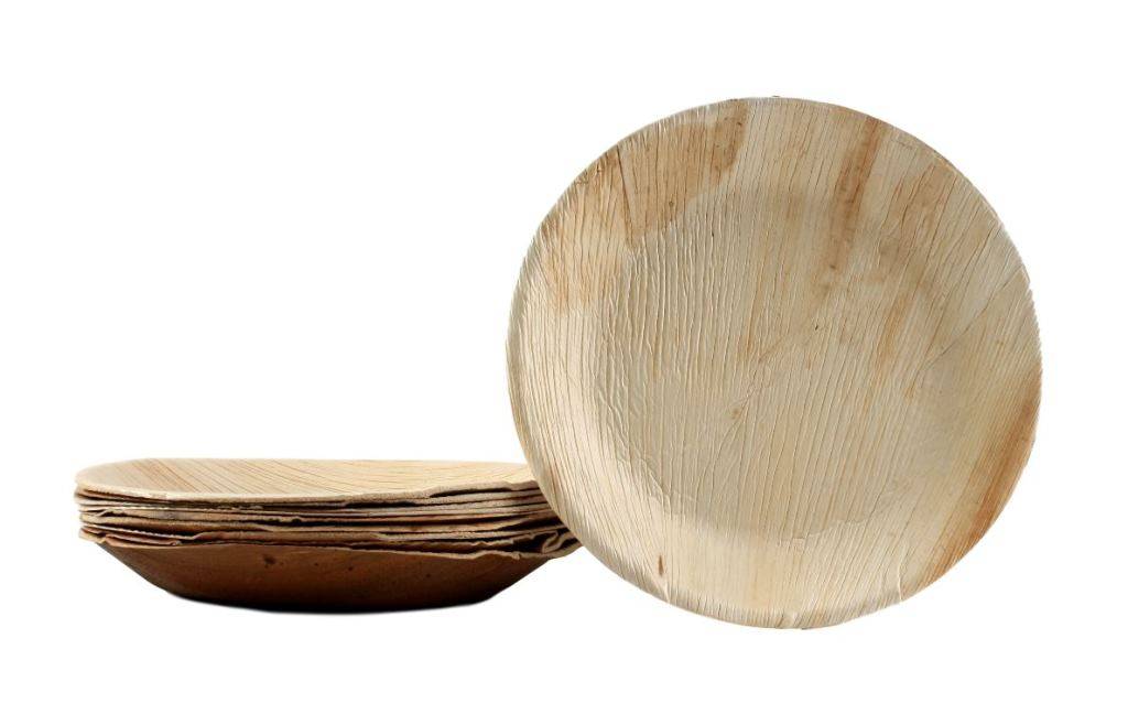 Ein Stapel runder, umweltfreundlicher Palmblattplatten, der eine Nahaufnahme ihrer Textur zeigt, auf weißem Hintergrund.