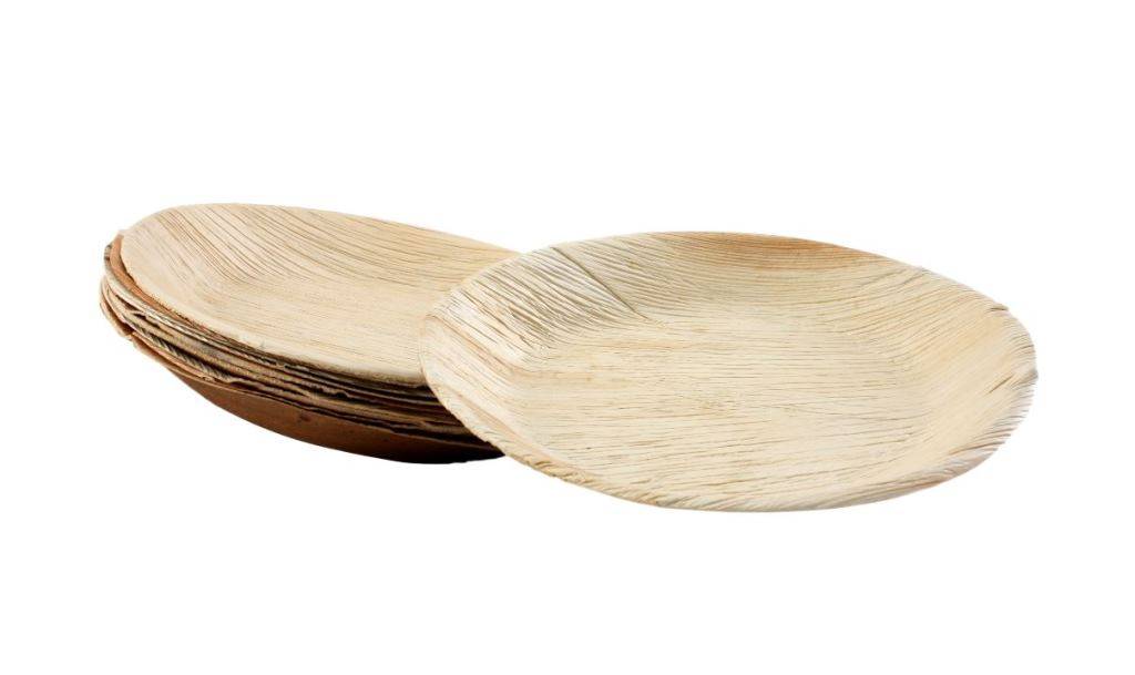 Ein rundes, naturfarben beschichtetes, wegwerfbares Palmblattgeschirr mit sichtbarer Körnerstruktur und einigen hellbraunen Flecken auf der Oberfläche.