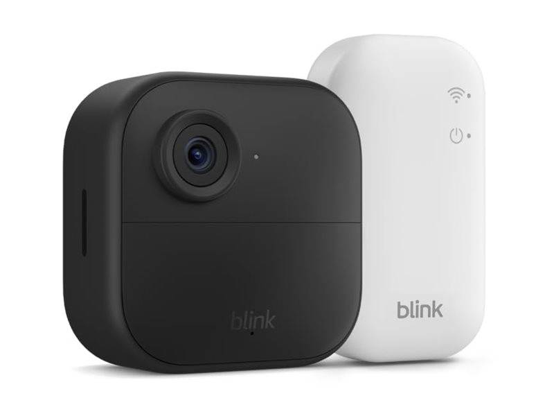 Eine schwarze Blink-Kamera und ein weißes Blink-WLAN-Modul stehen nebeneinander. Die Kamera verfügt über ein Objektiv und einen Bewegungsmelder.
