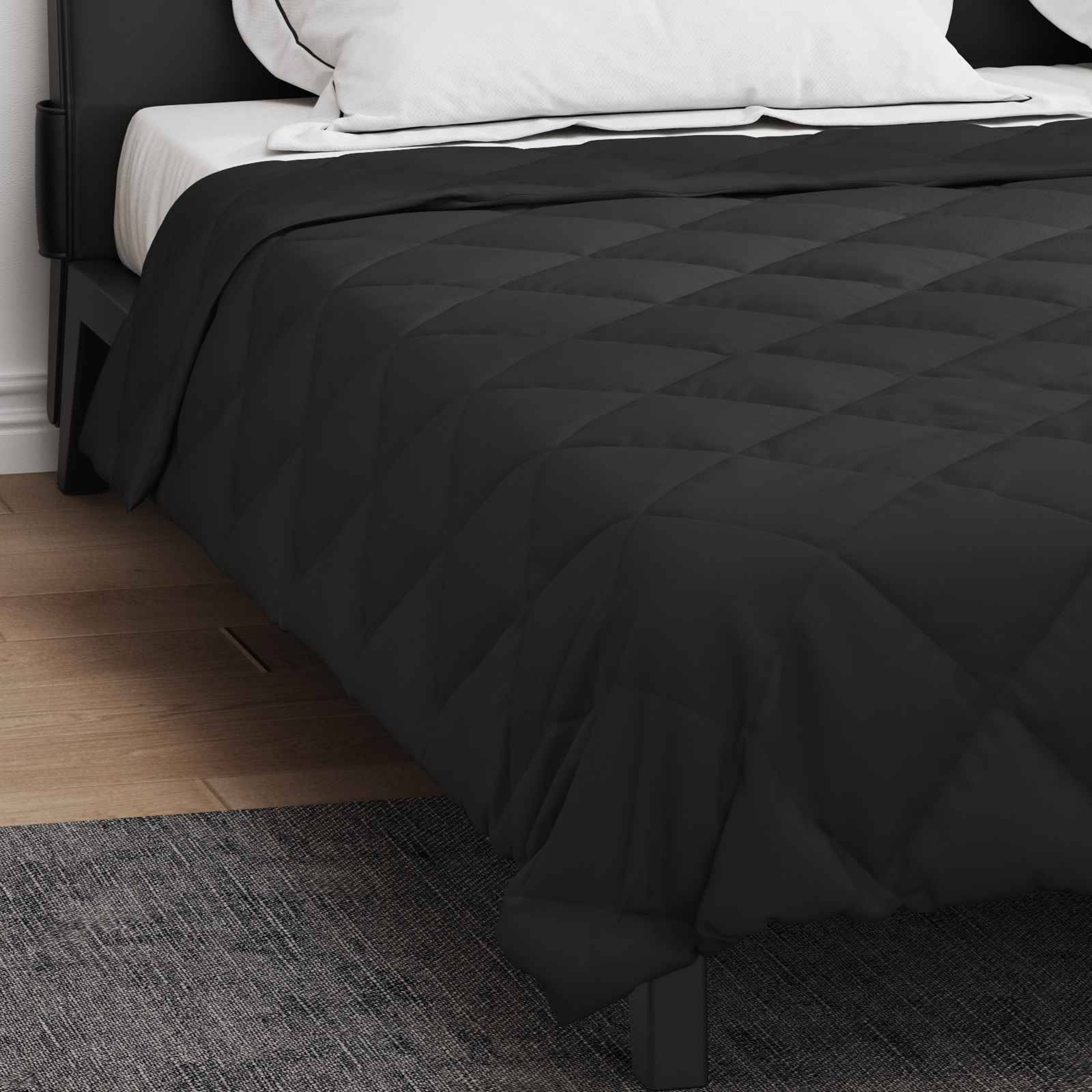Ein ordentlich gemachtes Bett mit weißen Kissen und einer schwarzen Steppdecke, eingebettet in einem modernen Schlafzimmer mit Holzboden.